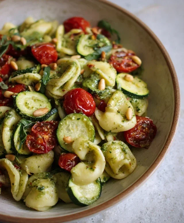 Pasta fredda con pesto di basilico, zucchine, pomodorini, olive e pinoli